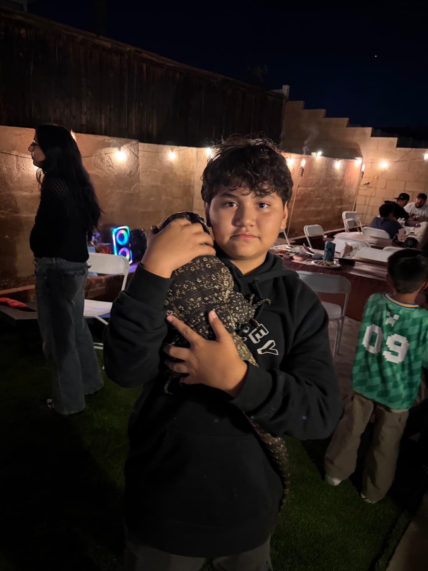 Nighttime event guest holding a tegu