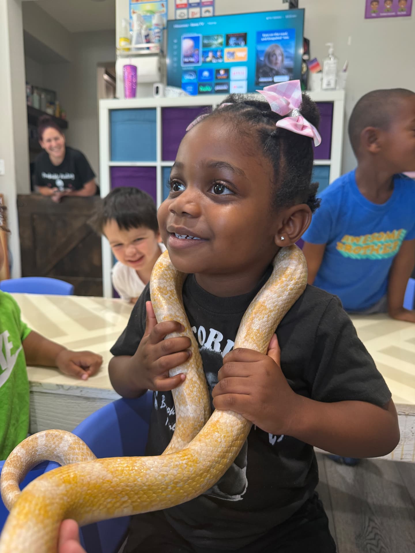 Smiling child holding a large yellow snake